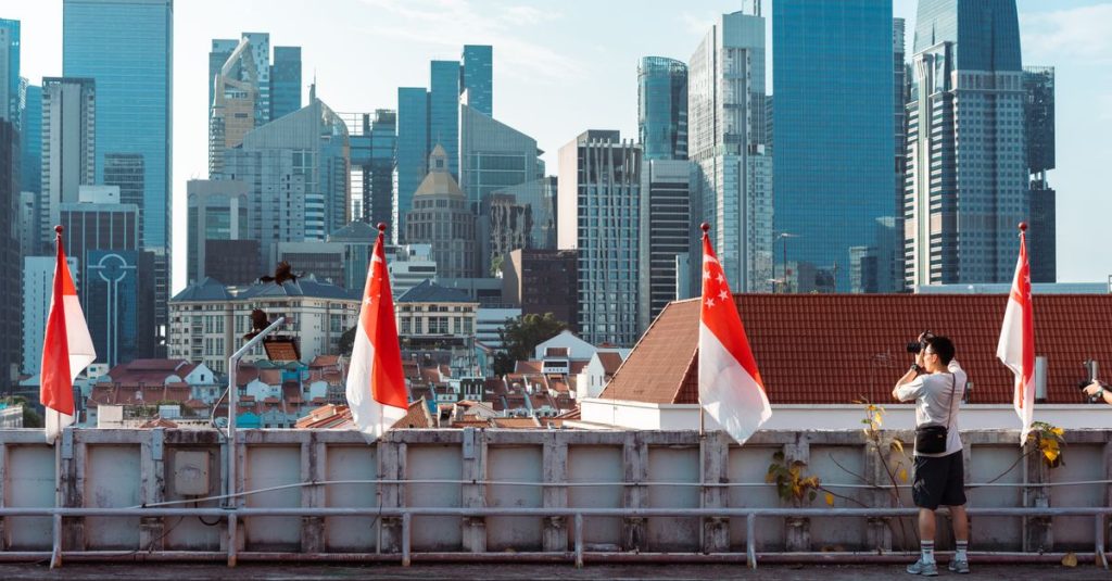 Drapeaux de Singapour sur un toit-terrasse devant les gratte-ciel du quartier financier