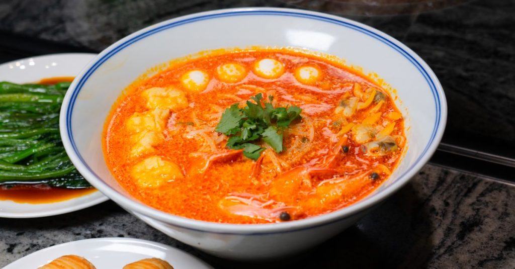 découvrez le laksa de singapour, une soupe de nouilles onctueuse au lait de coco, relevée d’épices et riche en saveurs.